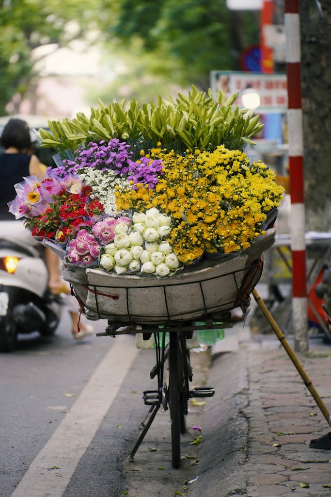 Bicycle filled with vibrant flowers on a street in Hanoi, Vietnam.
